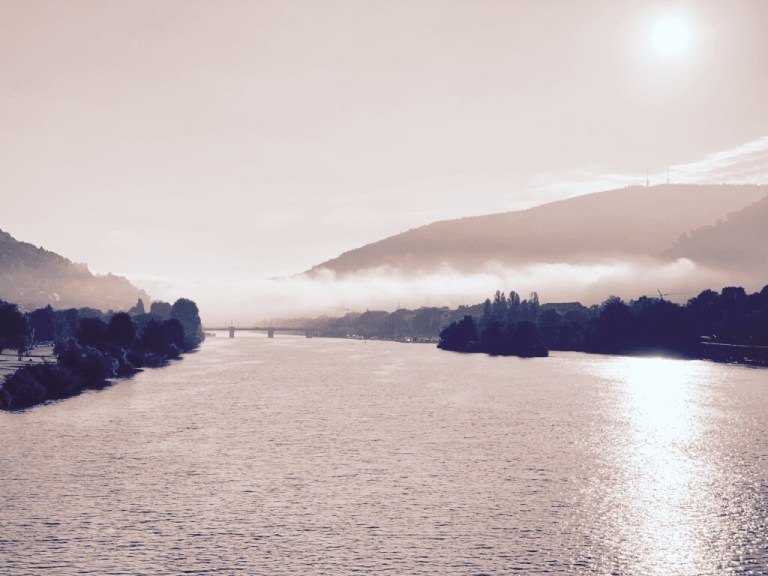 Flusslandschaft im Dunst mit Hügeln